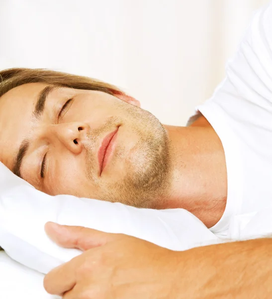 Młody mężczyzna śpi w swoim łóżku — Zdjęcie stockowe