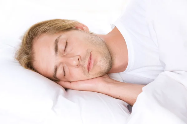 Giovane uomo dormire nel suo letto — Foto Stock