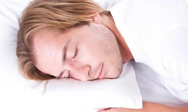 Ung mand sover i sin seng - Stock-foto