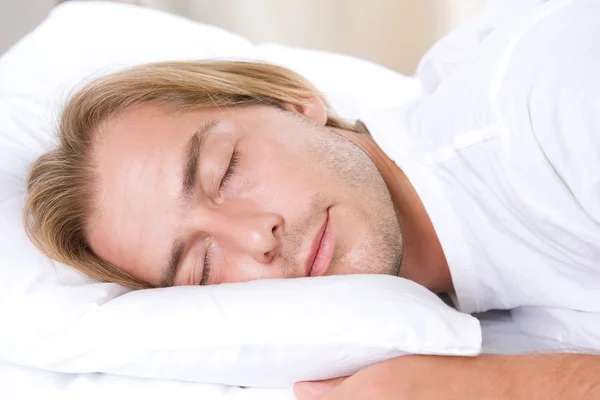 Jongeman slaapt in zijn bed — Stockfoto