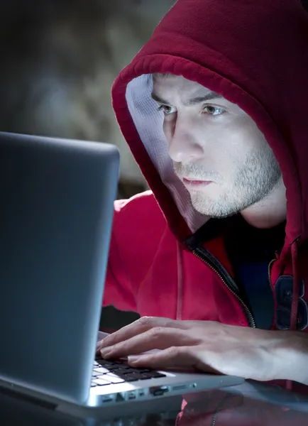 Hacker. Homem com computador em um quarto escuro — Fotografia de Stock