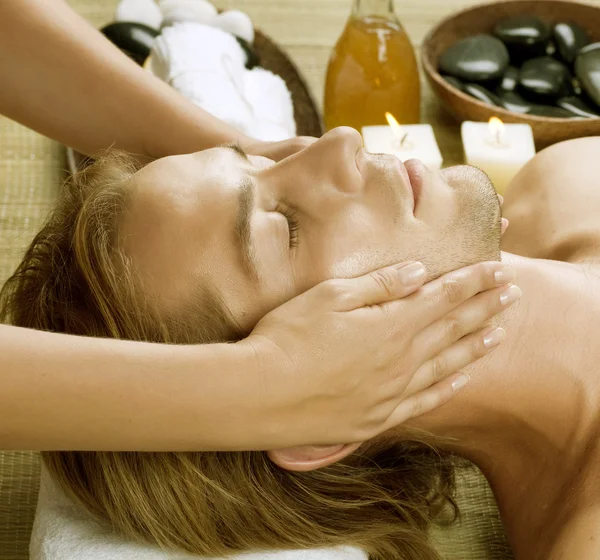Uzdrowisko. młody człowiek otrzymywać masaż twarzy — Zdjęcie stockowe