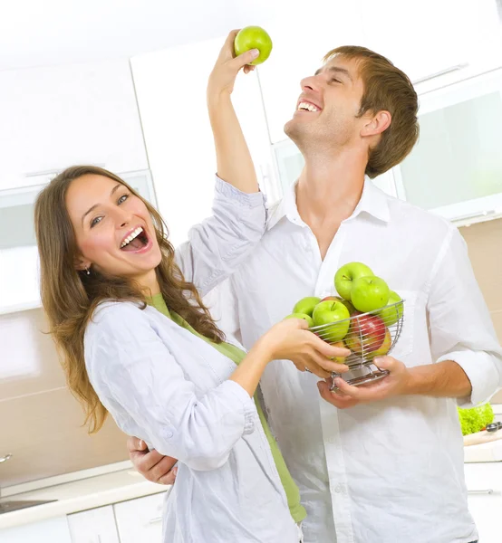 Casal feliz Comer frutas frescas. Divertindo-se em uma cozinha. Dieta — Fotografia de Stock