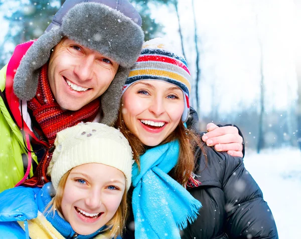 Familia Outdoors.Happy Familia con niño soplando Snow.Winter —  Fotos de Stock