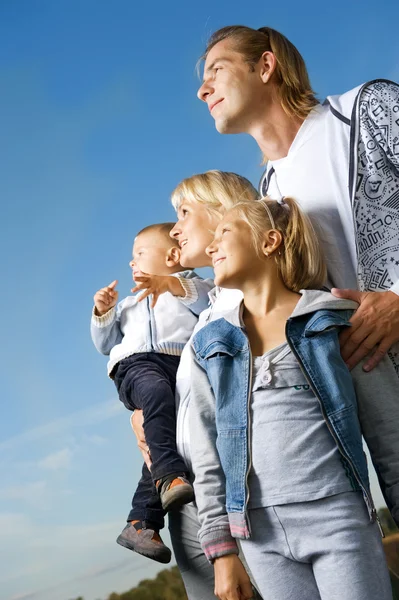 Здоровая семья на открытом воздухе. Счастливая мать и отец с детьми старше Б — стоковое фото