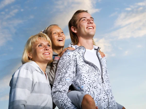 Zdravá rodina venkovní. Happy matka a otec s dítětem nad bl — Stock fotografie