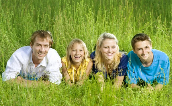 Happy vänner utomhus ligger på ett grönt gräs — Stockfoto
