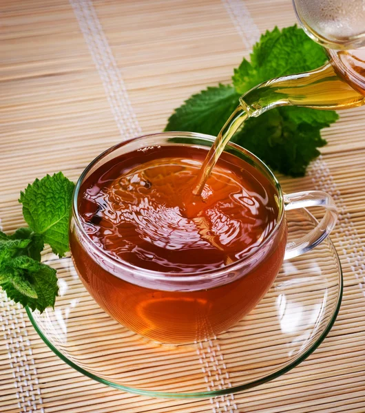 Gießen gesunden Tee mit Minze — Stockfoto