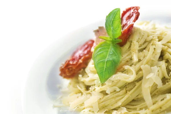 Italiaanse pasta met pestosaus, gedroogde tomaat, olijven, basilicum en — Stockfoto