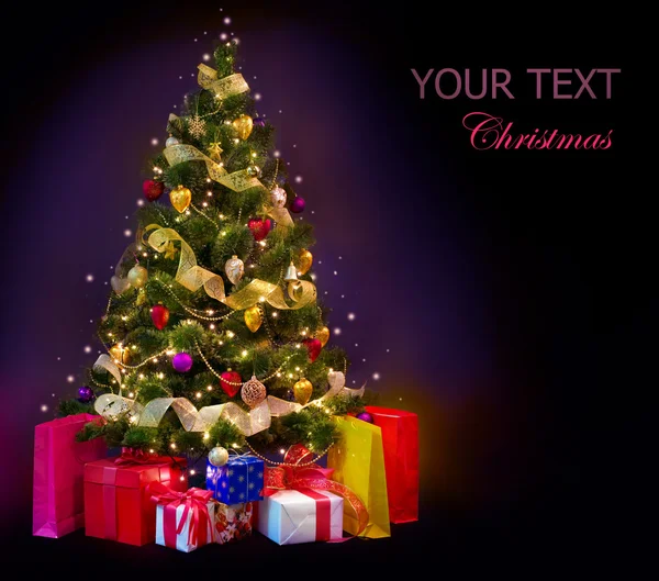 Vánoční stromeček s dárky izolovaných na černém — Stock fotografie
