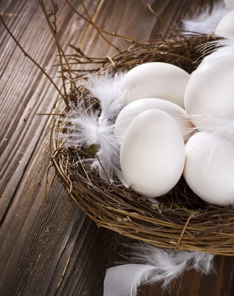 Ovos de Páscoa no ninho sobre fundo de madeira — Fotografia de Stock