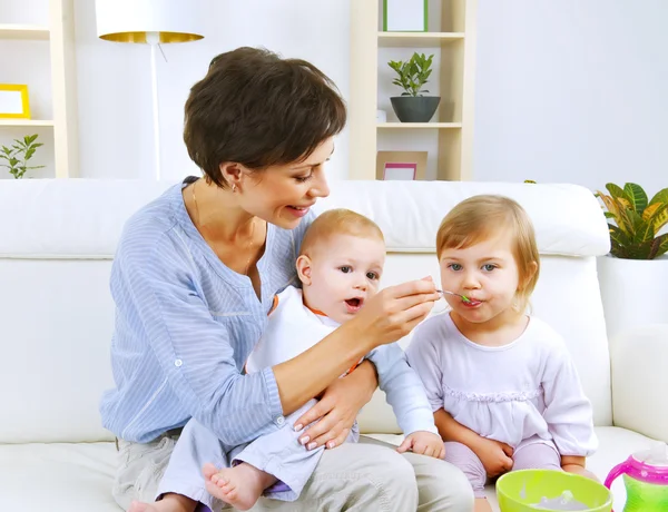 Мати годує немовлят їжею Ліцензійні Стокові Фото