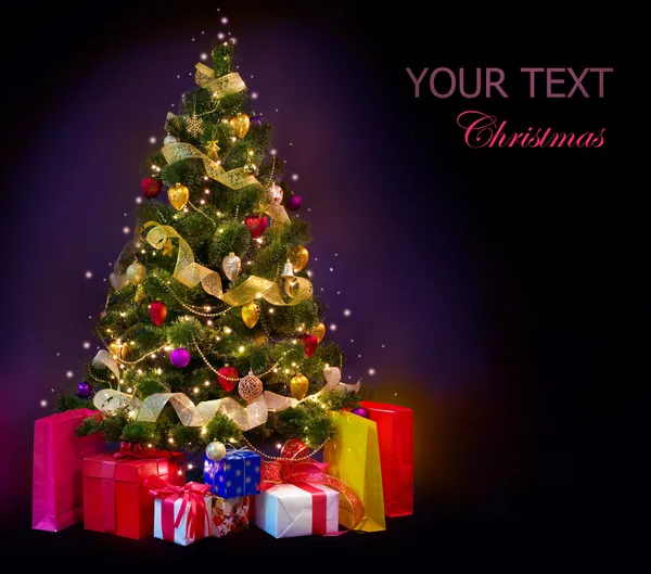 Weihnachtsbaum mit Geschenken isoliert auf schwarz Stockbild