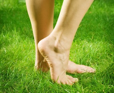 Woman's bare feet in green grass