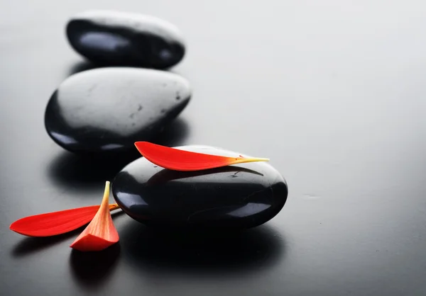 Spa stenen met rode bloemblaadjes — Stockfoto