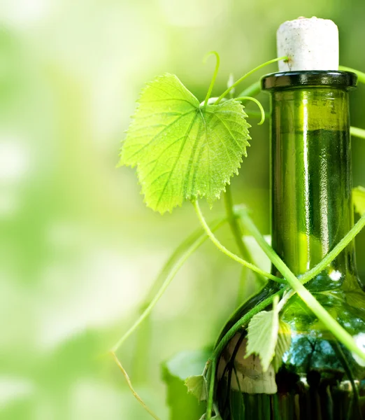 Botella de vino y hojas de uva — Foto de Stock