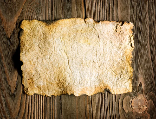 Starý list papíru přes dřevěné pozadí — Stock fotografie