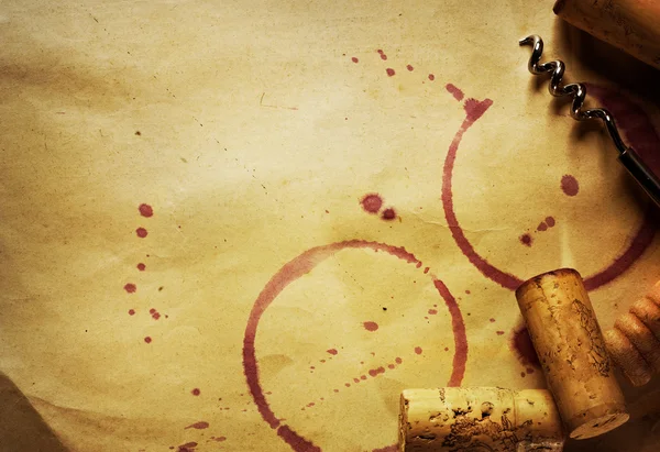 Cortiça de vinho, saca-rolhas e manchas de vinho tinto no fundo de papel vintage — Fotografia de Stock