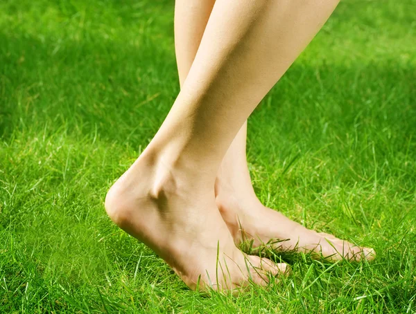 Женские босые ноги в зеленой траве — стоковое фото