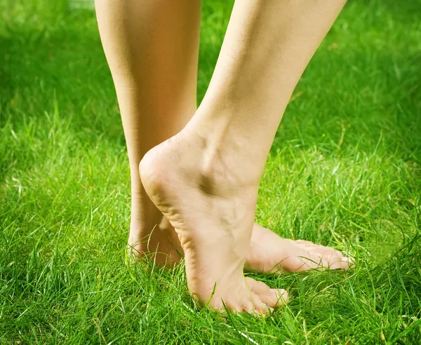 Женские босые ноги в зеленой траве — стоковое фото