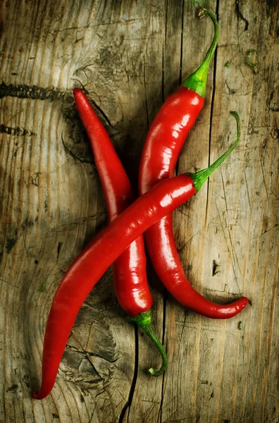 Red Hot Chili Peppers over wooden background — Stock Photo, Image