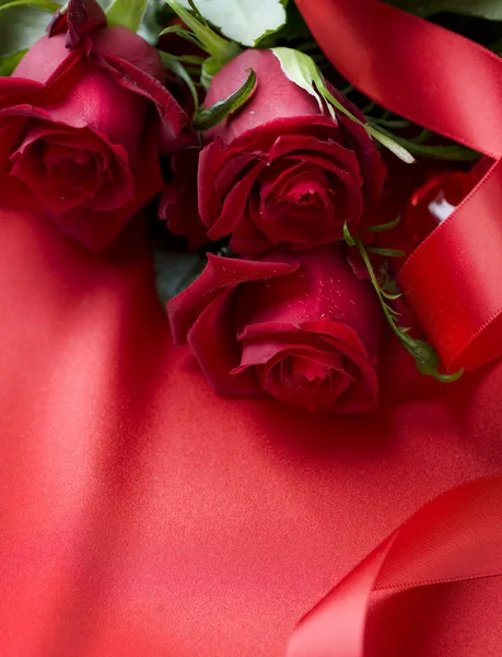 Μπουκέτο με κόκκινα τριαντάφυλλα πέρα από το υπόβαθρο του μεταξιού — Φωτογραφία Αρχείου