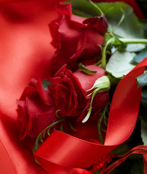 Ramo de rosas rojas sobre fondo de seda. San Valentín — Foto de Stock