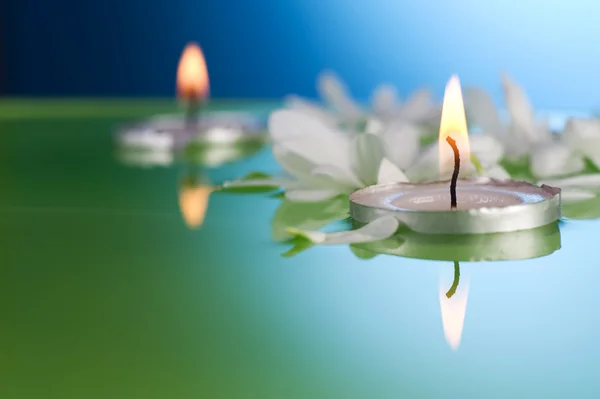 Brennende schwimmende Kerzen und Blumen — Stockfoto