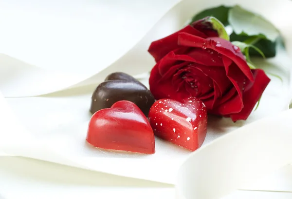Valentinskarte. Schokoladenherzen und rote Rose — Stockfoto
