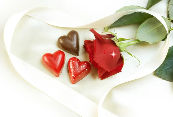 Tarjeta de San Valentín. Corazones de chocolate y rosa roja —  Fotos de Stock