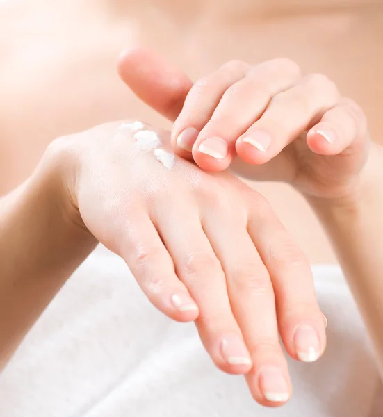 Hembra aplicando crema hidratante a sus manos después del baño —  Fotos de Stock