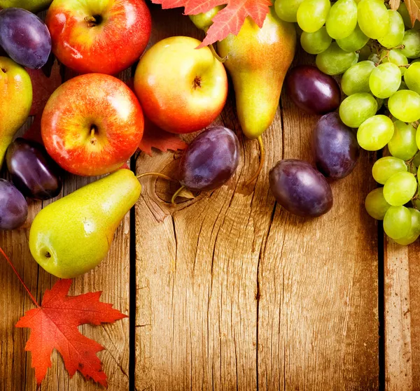 Frutas ecológicas sobre fondo de madera. Cosecha de otoño — Foto de Stock