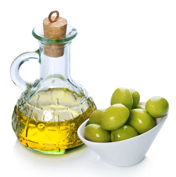 Natives Olivenöl extra und grüne Oliven über weißen — Stockfoto
