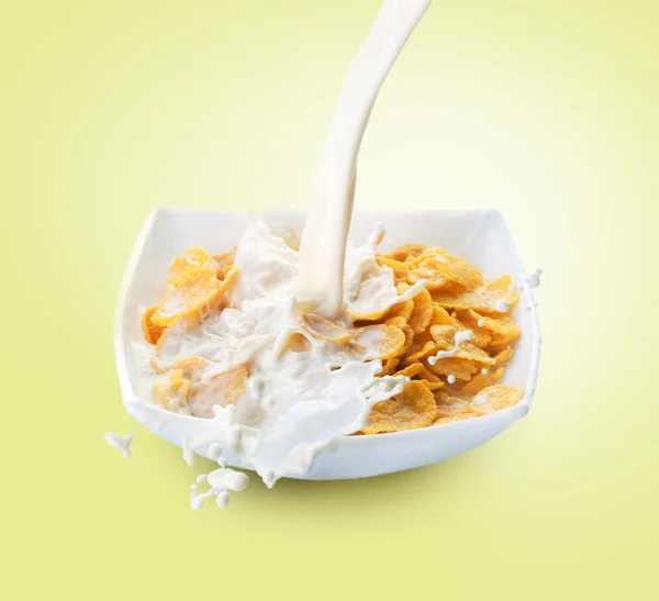 Desayuno saludable. Copos de maíz y salpicaduras de leche —  Fotos de Stock