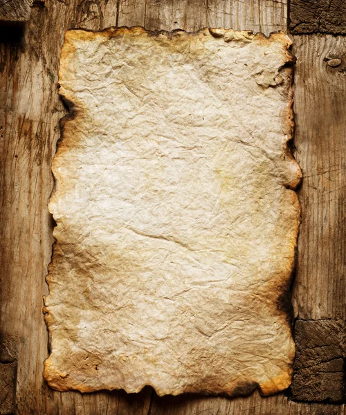Hoja de papel vieja sobre fondo de madera — Foto de Stock