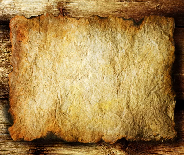 Folha de papel velha sobre fundo de madeira — Fotografia de Stock