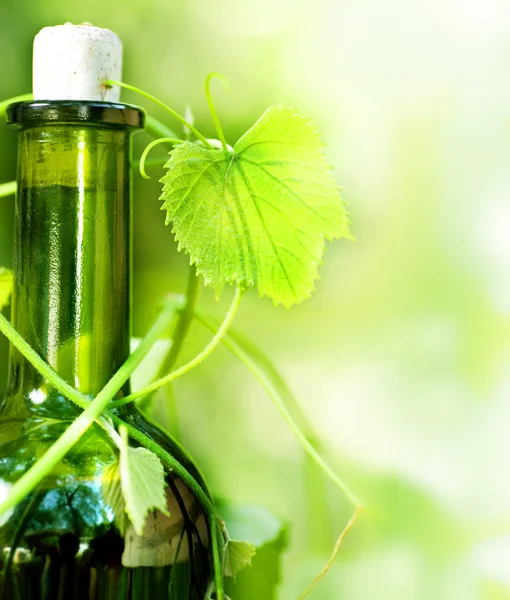 Бутылка вина и виноградные листья — стоковое фото