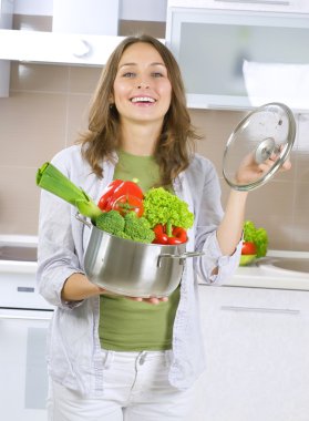 Beautiful Young Woman cooking fresh Vegetables.Dieting Concept. clipart