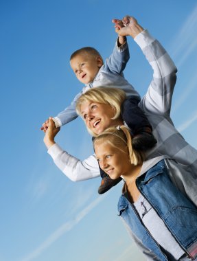 sağlıklı aile açık. çocuklar üzerinde mavi gökyüzü ile mutlu anne
