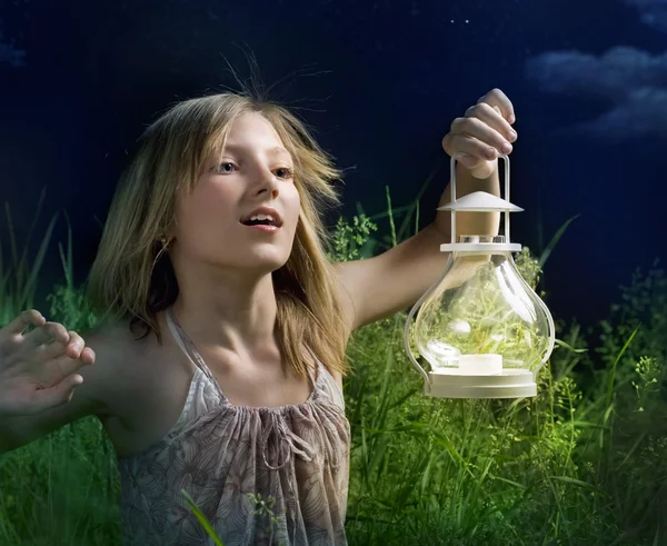 Meisje op een groen veld uitgevoerd. mystieke nacht — Stockfoto