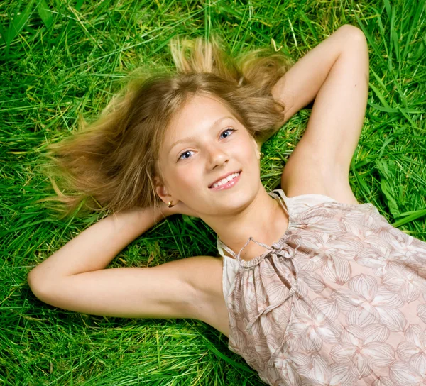 Šťastná dívka leží na zelené trávě — Stock fotografie