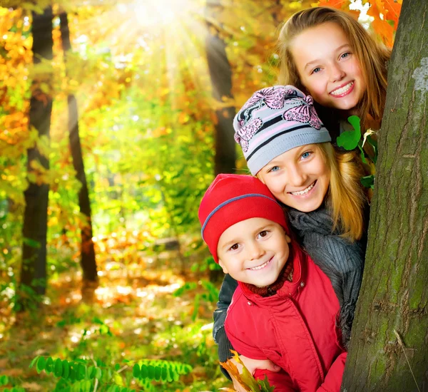 Niños felices divirtiéndose en el parque de otoño.Al aire libre —  Fotos de Stock
