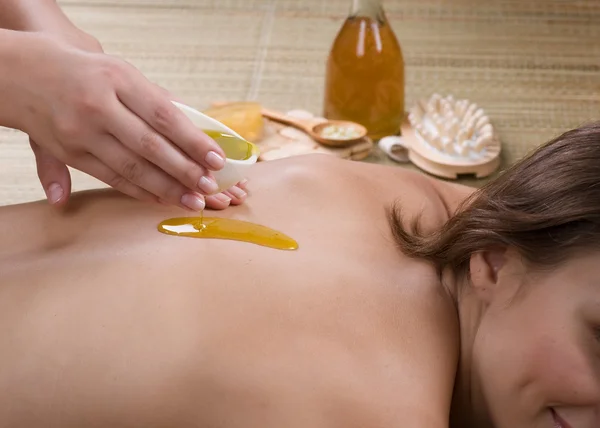 Spa. Jeune femme se faisant masser. Verser l'huile de massage — Photo