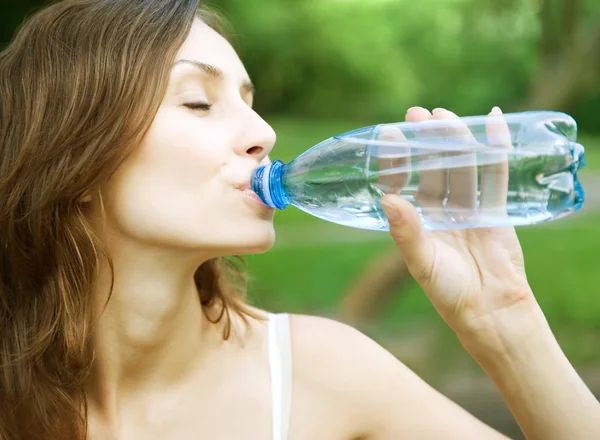 Молодая здоровая женщина пьет воду из бутылки — стоковое фото
