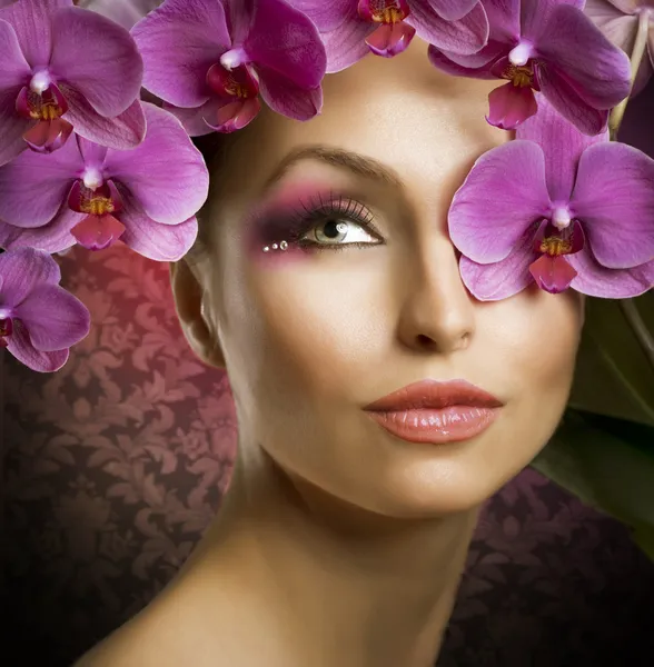 Mode vacker kvinna stående med orkidé blommor över svart — Stockfoto