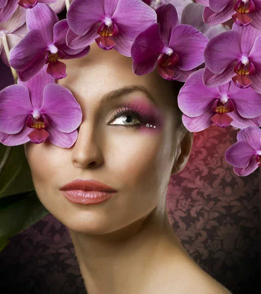 Hermoso retrato de mujer con flores de orquídea sobre negro — Foto de Stock