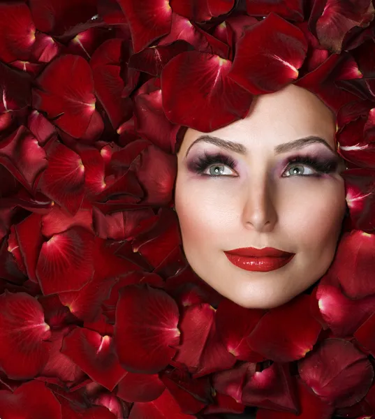 Piękna kobieta twarzy i płatki róży. Doskonałej skóry — Zdjęcie stockowe
