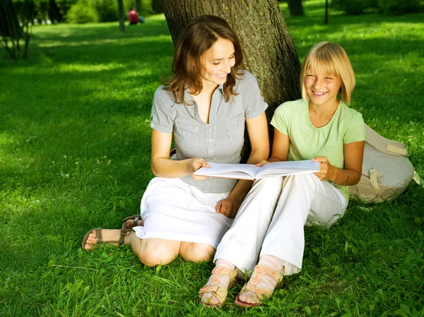 Matka a dcera, čtení knihy v parku. vzdělávání concep — Stock fotografie