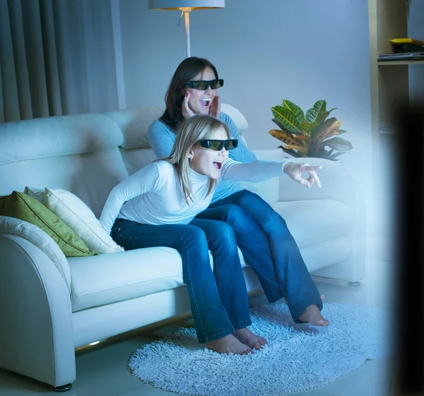 Мать с дочерью смотрят 3D-фильм по телевизору — стоковое фото