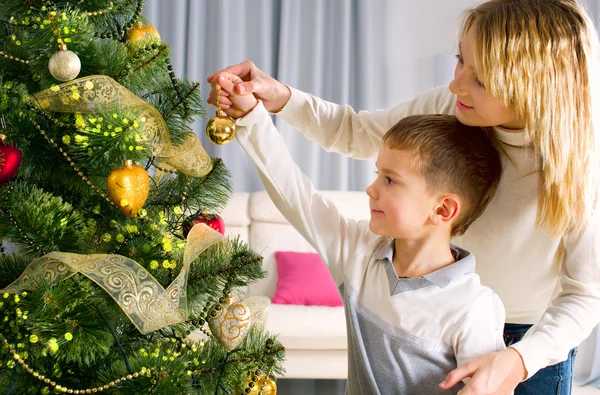 Crianças decorando uma árvore de Natal com bugigangas na sala de estar — Fotografia de Stock